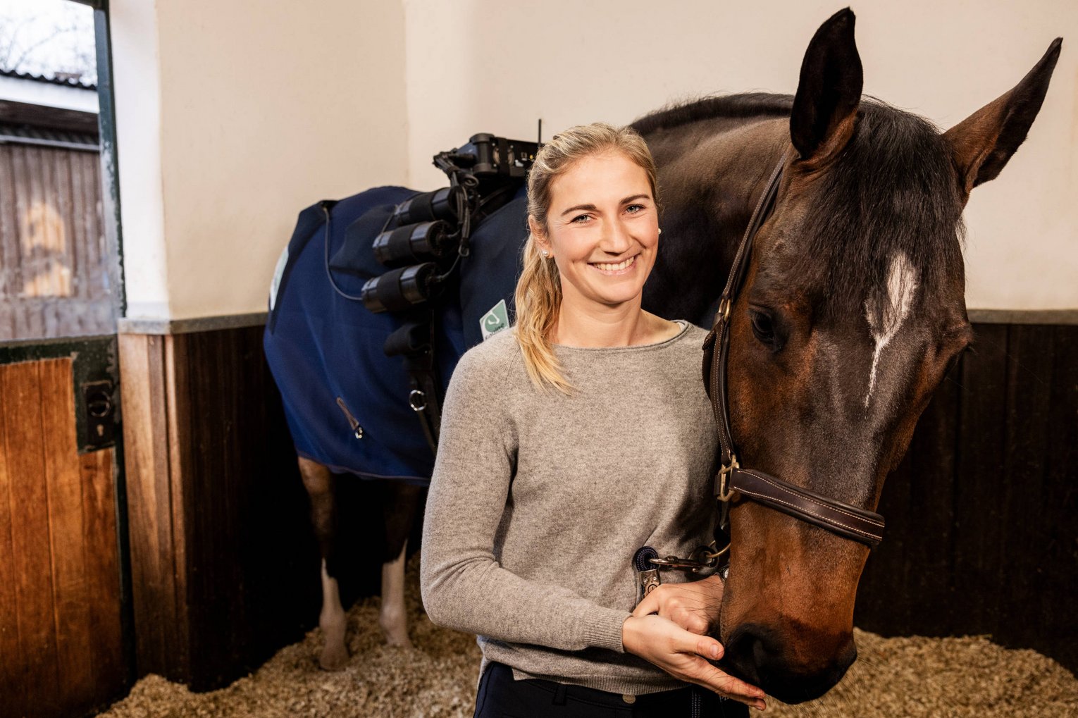 Equine Balance Katharina Rhomberg Katharina Rhomberg steht neben ihrem Wallach